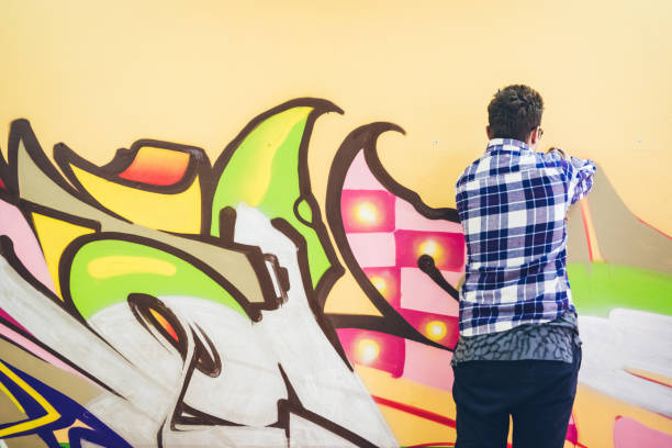 istock Man painting graffiti on orange wall 1016074226