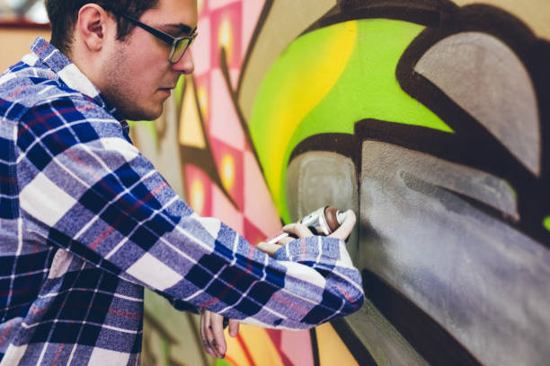istock Man painting graffiti on orange wall 1016074406