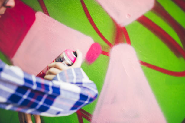 istock Man painting graffiti on orange wall 1016074626