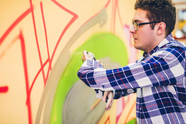 istock Man painting graffiti on orange wall 1016077656