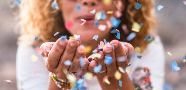 confetti du belle femme défocalisé coup de mains. concept de célébration et d’événement. bonheur et image colorée. mouvement et le bonheur s’amuser - souffle photos et images de collection