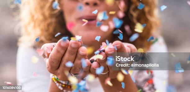 Beautiful Defocused Woman Blow Confetti From Hands Celebration And Event Concept Happiness And Colored Image Movement And Happiness Having Fun Stock Photo - Download Image Now