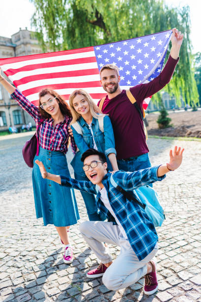 istock smiling multicultural students with american flag in park 1016087442