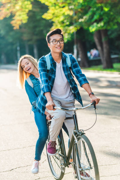 istock happy multiethnic students riding bicycle together on street 1016087676