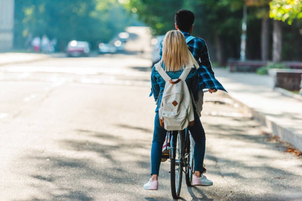 istock back view of students riding bicycle together on street 1016087692