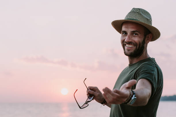istock Young man enjoying sunset by the sea 1016087966