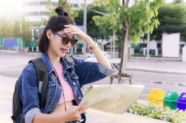 istock traveler girl's hold a map and looking for destination 1016096684