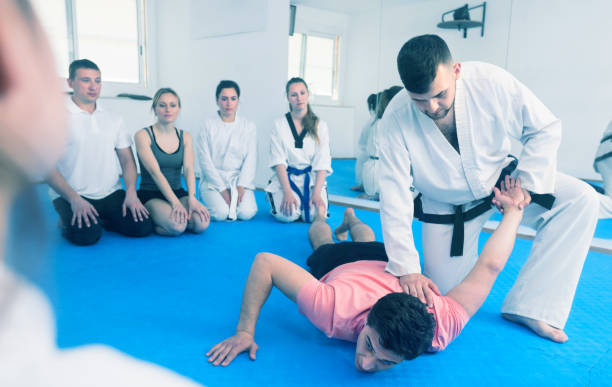 istock Coach showing new submission hold in taekwondo class 1016099200