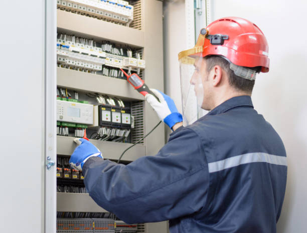 Electrician testing for voltage on terminal block Tehnician with red hardhat testing equipment in electrical room electrician multimeter stock pictures, royalty-free photos & images