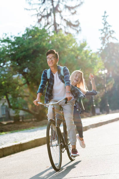 istock happy multiethnic students riding bicycle together on street 1016102794