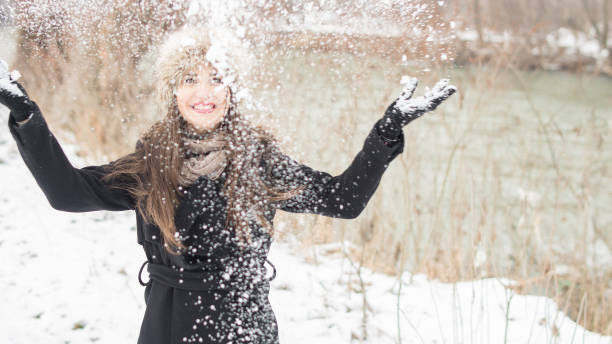 istock Caucasian brunette woman throwing snow 1016108410
