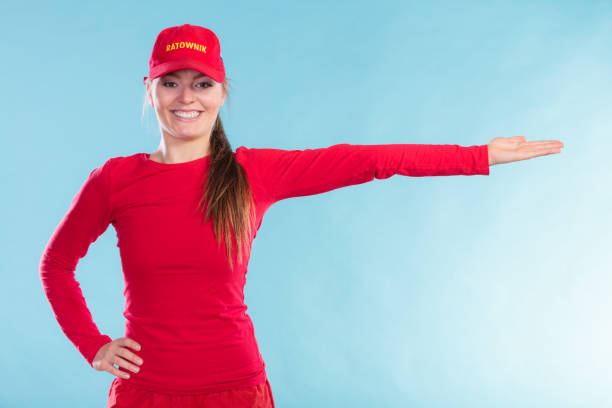 istock Happy lifeguard woman in cap pointing direction. 1016116328