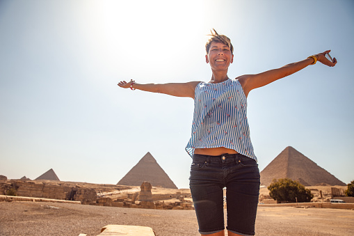 Carefree Adult Woman Tourist With Pyramids of Giza in Background.