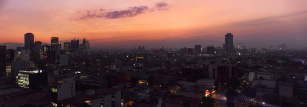 Aerial view of a large part of the skyline of Mexico City taken during a wonderful winter sunset. Panoramic composition with brands and signs removed.
