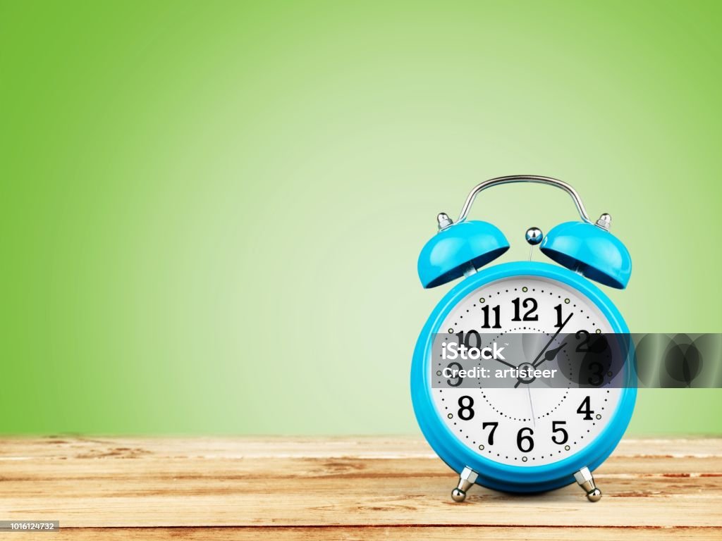 Time. Blue Retro alarm clock on wooden table Alarm Stock Photo