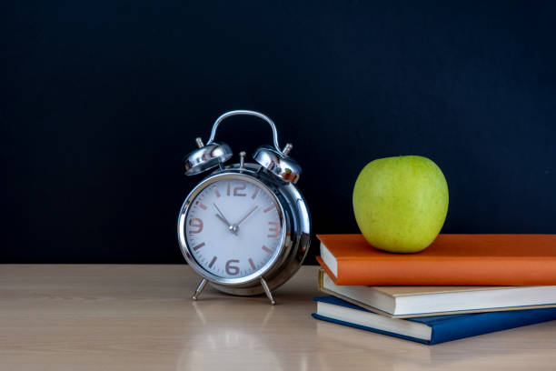 istock school books with alarm clock on  school board background 1016124986