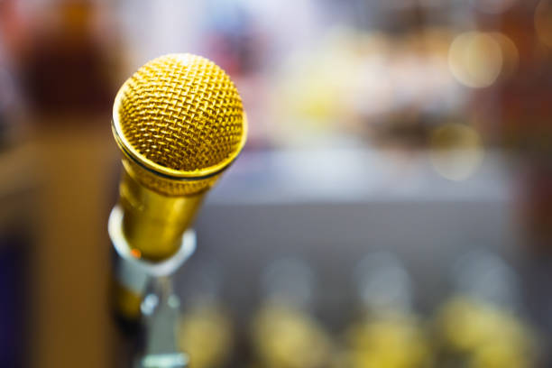 istock Golden microphone on blur bokeh background 1016137550