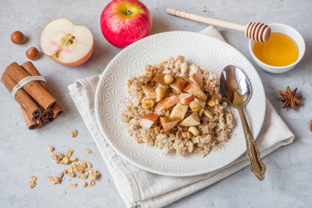 istock Oatmeal with fresh apples, nuts and cinnamon for Breakfast on the table, close-up, horizontal 1016152606