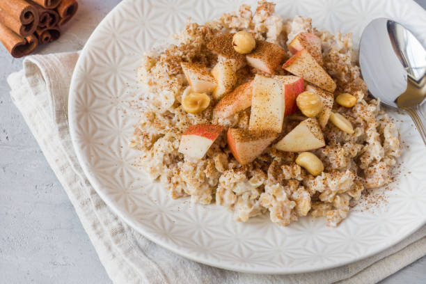 istock Oatmeal with fresh apples, nuts and cinnamon for Breakfast on the table, close-up, horizontal 1016152742