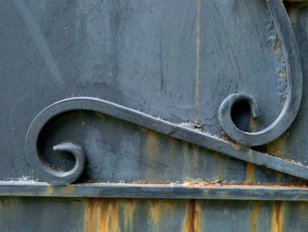 istock Texture of iron, two spiral curls on old gray door, ancient pattern 1016157374