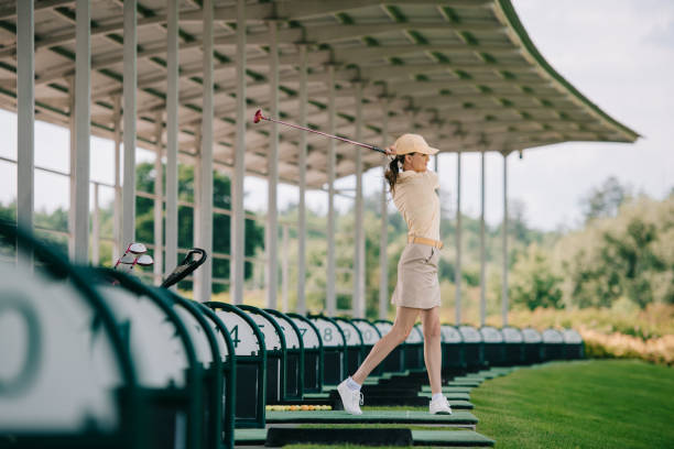 istock woman in yellow cap and polo playing golf at golf course 1016161272