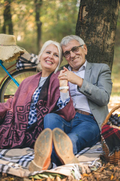 istock Romantic senior couple seated on the grass and relaxing while picnic. 1016161682