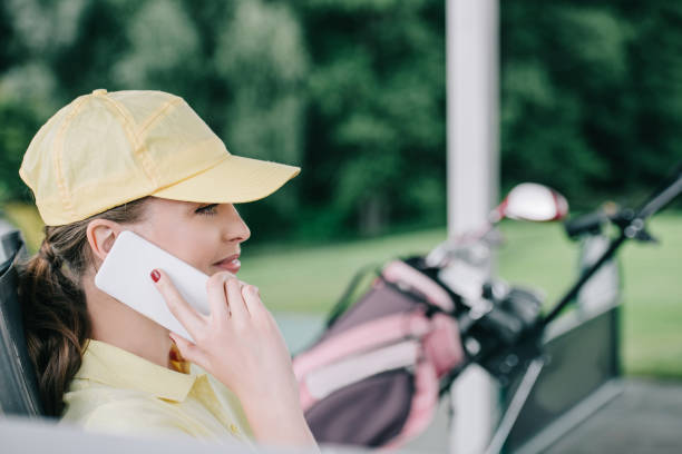 istock side view of female golf player in cap talking on smartphone at golf course 1016164990