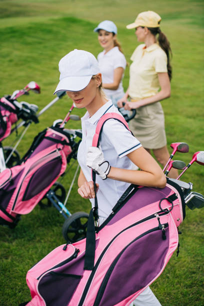 istock selective focus of women in caps with golf equipment on golf course 1016165452
