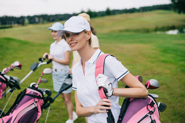 istock smiling women in caps with golf equipment on golf course 1016167992
