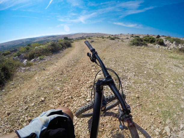 istock Mountain biker sitting and resting under blue sky 1016174166
