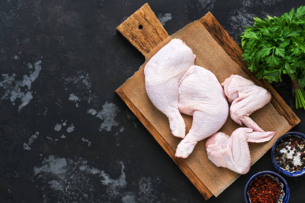istock Raw chicken wings and legs on a cutting Board with spices. Rustic dark gray background, copy space, flat lay. 1016186184
