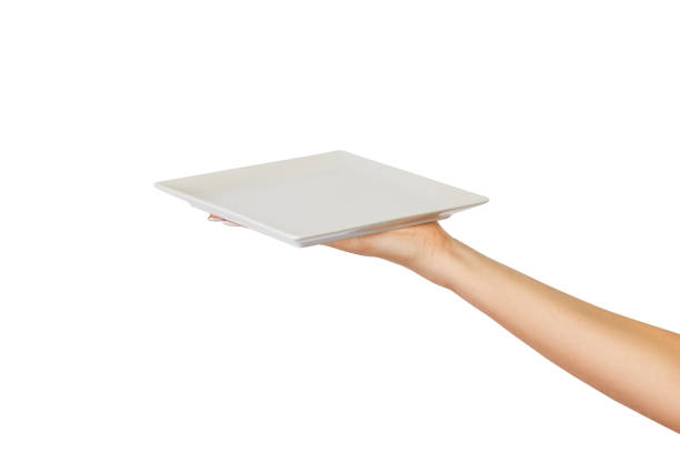 istock Blank white square matte plate in female hand. perspective view, isolated on white background 1016186696