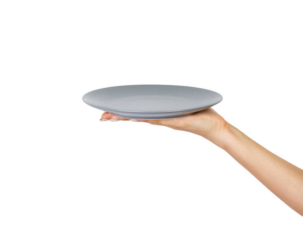 istock Blank empty round gray matte plate in female hand. perspective view, isolated on white background 1016186698