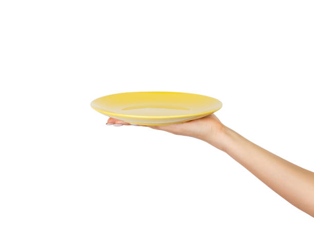 istock Blank empty round yellow plate in female hand. perspective view, isolated on white background 1016186702