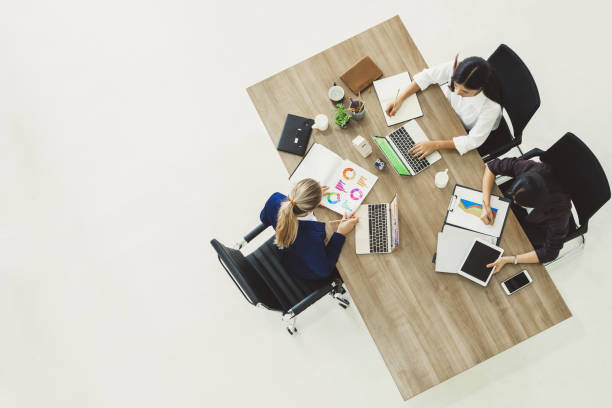 istock Three business woman discussing work on table in office, top view 1016194788
