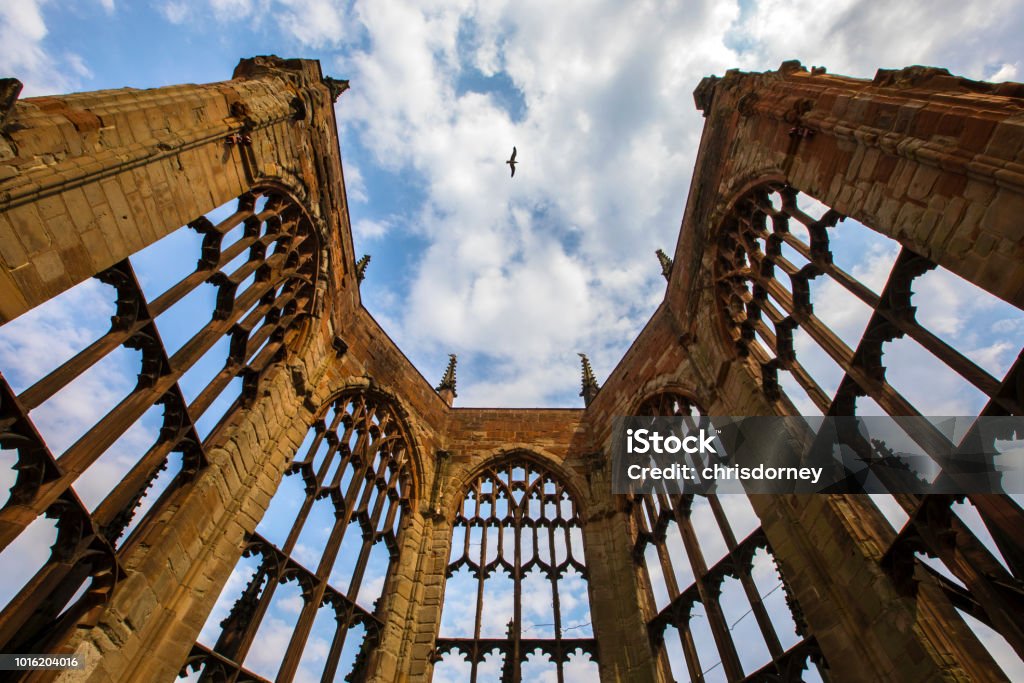 The Bombed Ruins of the old Coventry Cathedral in Coventry, UK A bird flies over the bombed-out ruins of the Cathedral Church of St. Michael, also known as Coventry Cathedral in the UK.  The Cathedral was destroyed in an air raid during the Second World War. Coventry Stock Photo
