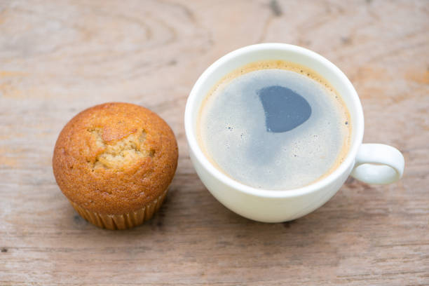 istock Banana cup cake and black coffee on wood table 1016204638