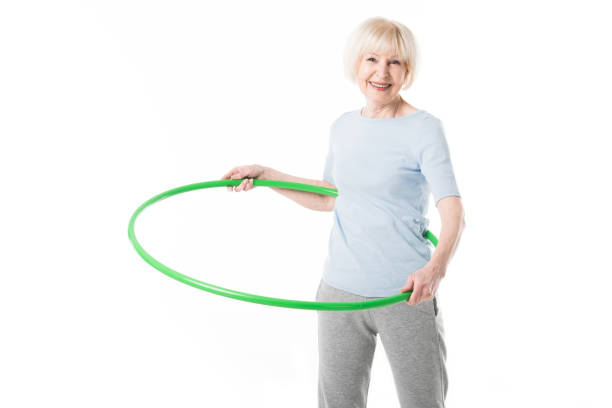 istock Senior sportswoman doing hula hoop exercise isolated on white 1016207918