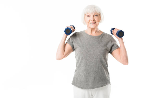istock Smiling senior sportswoman doing excercise with dumbbells isolated on white 1016208114