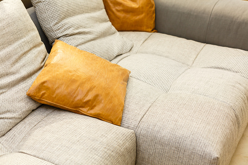 White leather sofa with orange pillow