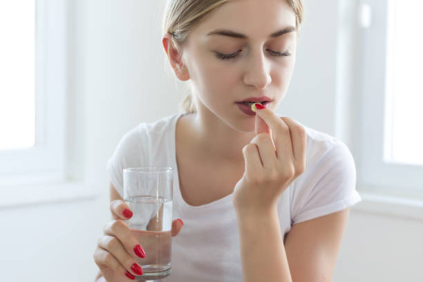 istock Young woman taking pills 1016220258