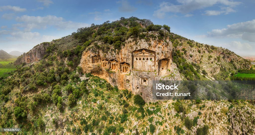 Ancient Lycian Rock Tombs of Dalyan, Mugla, Turkey Above the river's sheer cliffs are the weathered façades of Lycian tombs cut from rock, circa 400 BC. Caunus Stock Photo