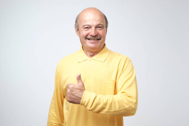 istock Handsome, bald man with his thumb up in sign of optimism on white background 1016237694