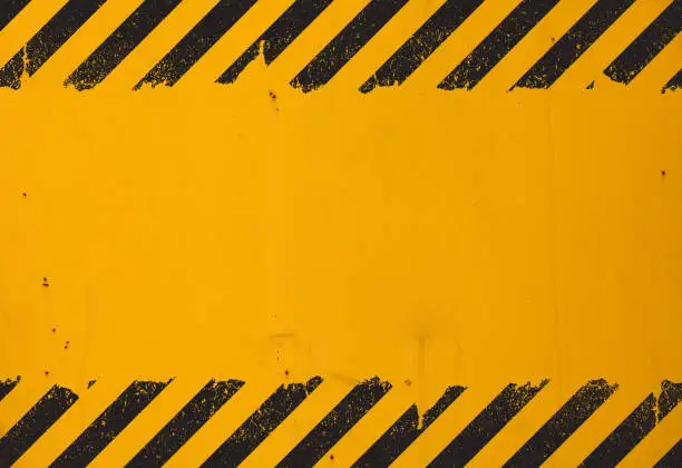 Photo of Yellow background with black grunge hazard sign