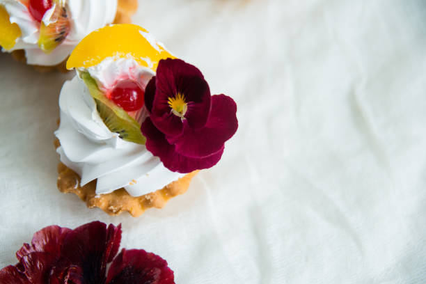 istock cake with fresh fruit and edible flowers Pansy Flowers on light background 1016256732