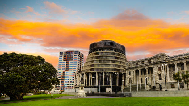 The Beehive, Wellington, New Zealand New Zealand parliament building the beehive under a vibrant orange sunset. beehive new zealand stock pictures, royalty-free photos & images