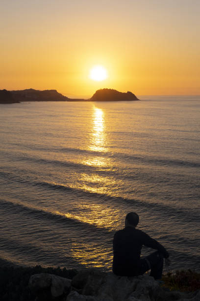 istock Man admiring the sunset sitting on the coast 1016259666