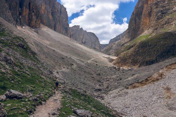 istock a man walks along a path in the Italian Alps (Italian Dolomitres, Val De Mezdi) 1016265842