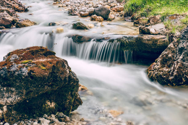 istock Forest stream running over mossy rocks in Alps (Italian Dolomites) 1016266026