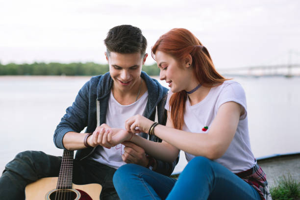 istock Nice pleasant man putting a bracelet on his girlfriends hand 1016272374